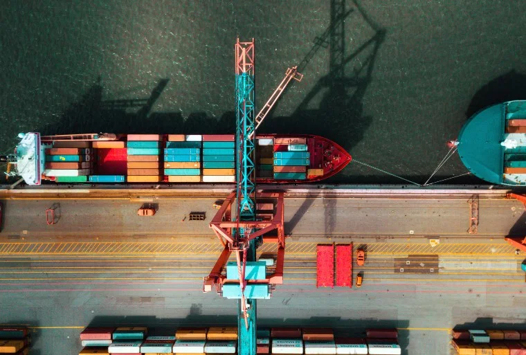 Crane lifts containers from a ship anchored in port