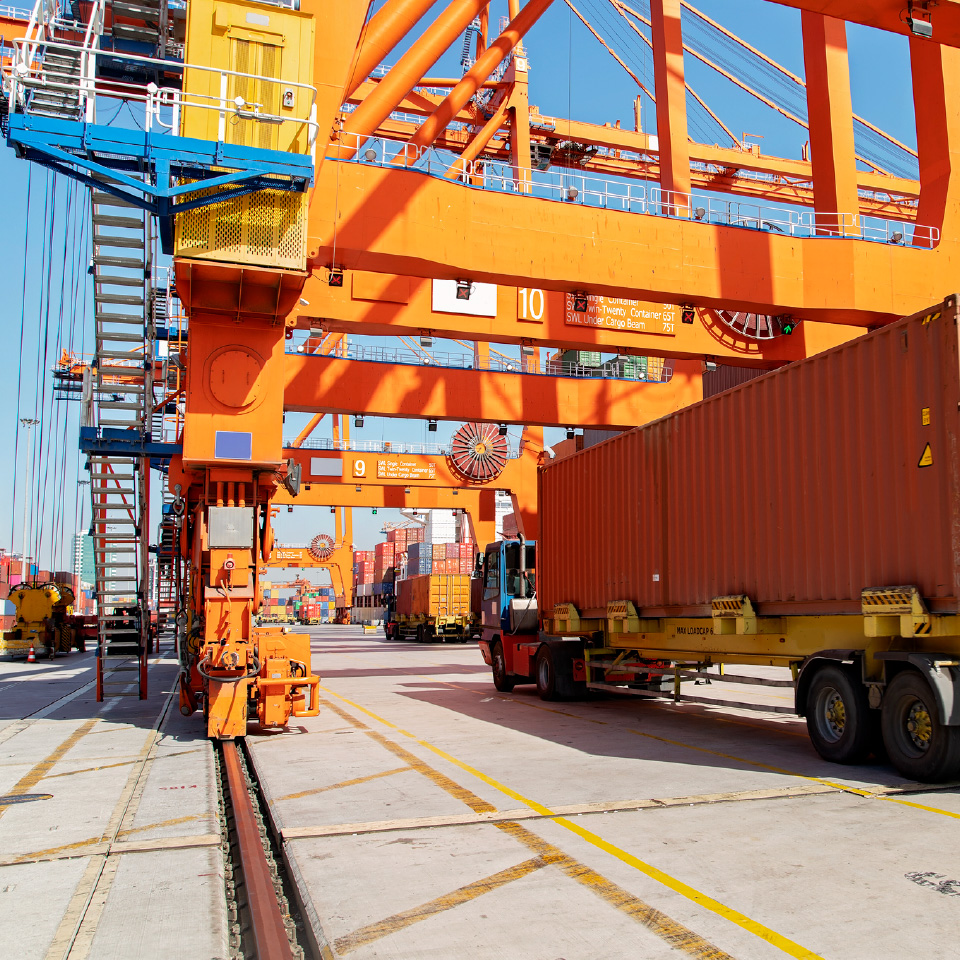 orange cranes with truck in port-80