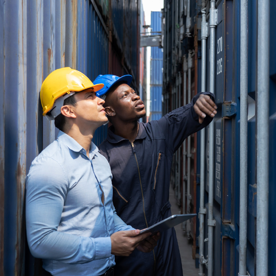 two men examining container-80